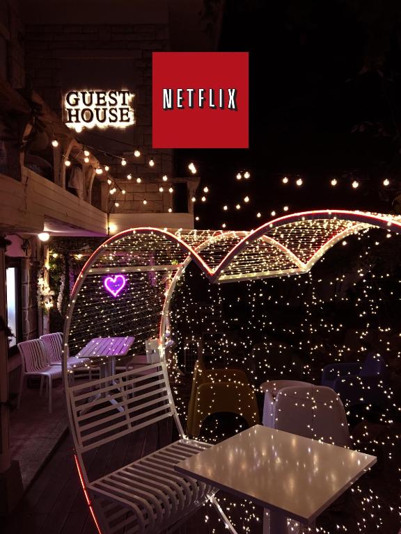 a table and chairs on a balcony with lights at OkiDoki House in Seoul