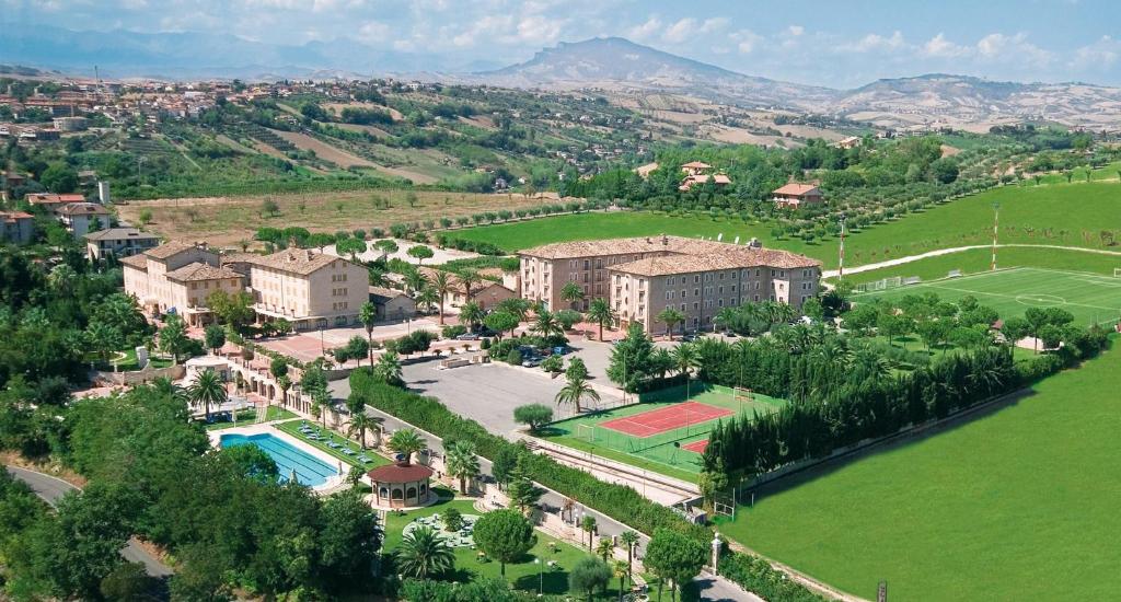 vista aerea di un resort con campo da tennis di Hotel Casale a Colli del Tronto