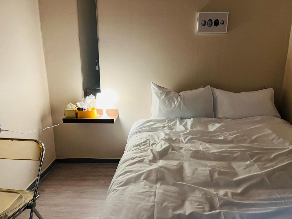 スウォンにあるStay Ducksanのベッドルーム(白いベッド1台、ナイトスタンド付)