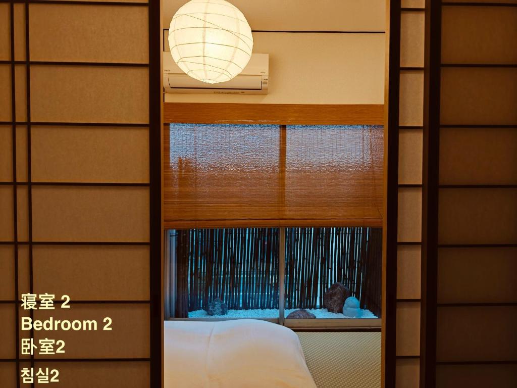 a mirror in a bedroom with a child looking out the window at Leisureyado 悦宿 USJ 西九条 in Osaka