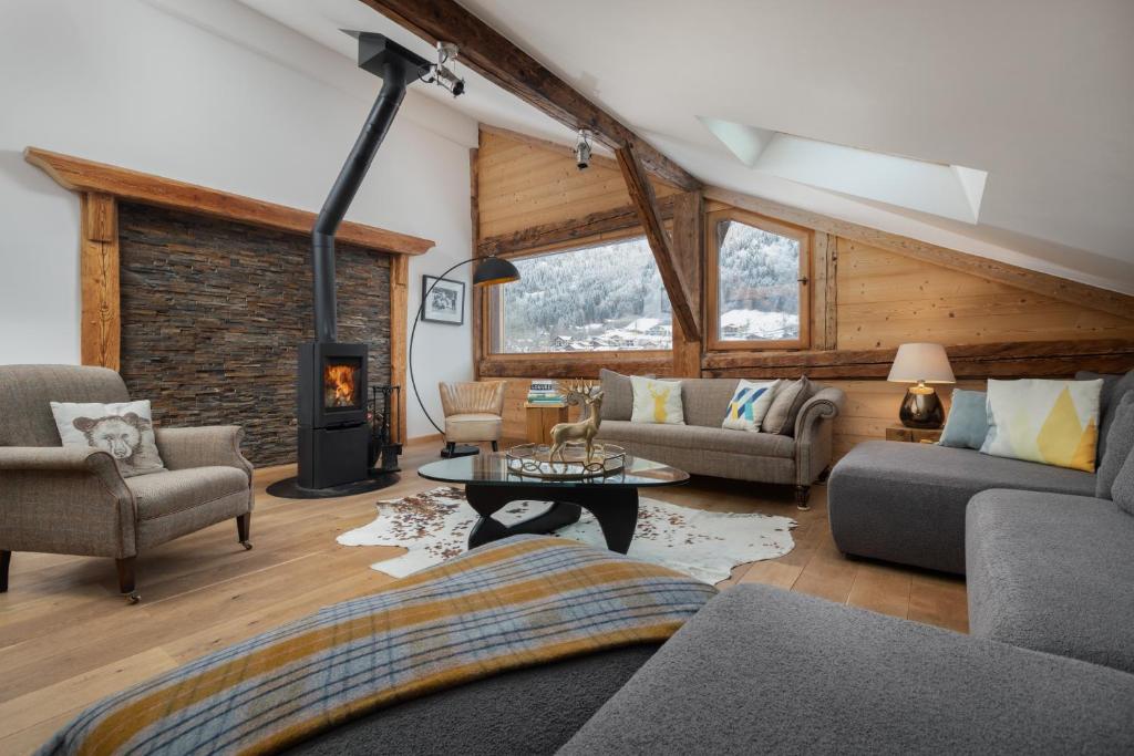 a living room filled with furniture and a fireplace at Chalet Vogue in Morzine