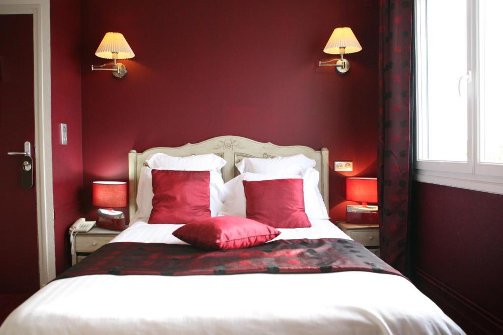 a red bedroom with a bed with red pillows at Hotel La Villa Julia in Agon Coutainville