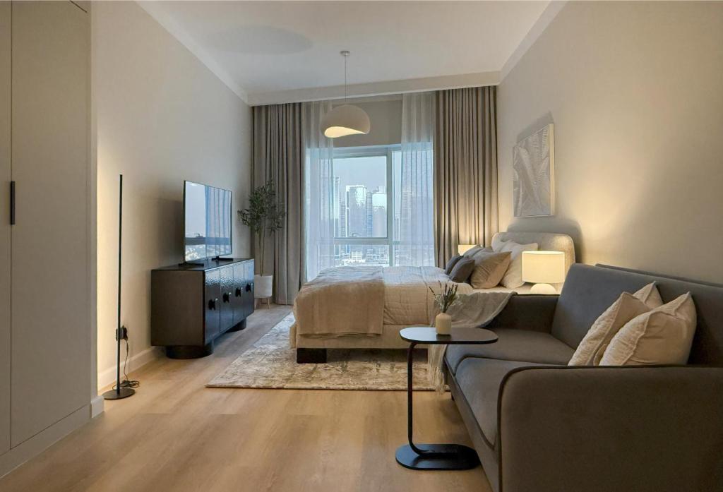 a living room with a couch and a bed at Signature Studio JLT in Dubai