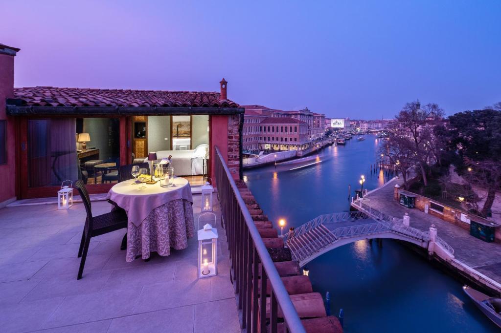 a balcony with a table and a view of a river at Hotel Santa Chiara in Venice