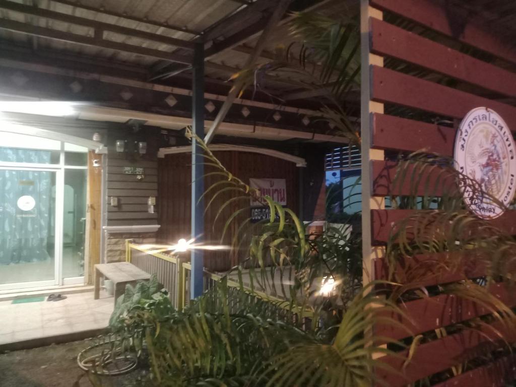 a patio with a bench and plants in front of a building at มังกรเลโฮสเทล Mangkonlay Hostel in Ban Khlong Pak