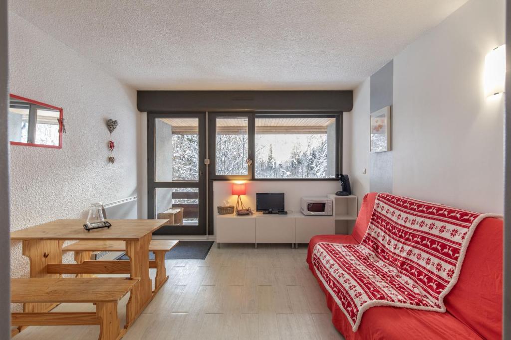 un salon avec un canapé rouge et une table dans l'établissement Cosy Marmottes - Au cœur du Parc National, à Barèges