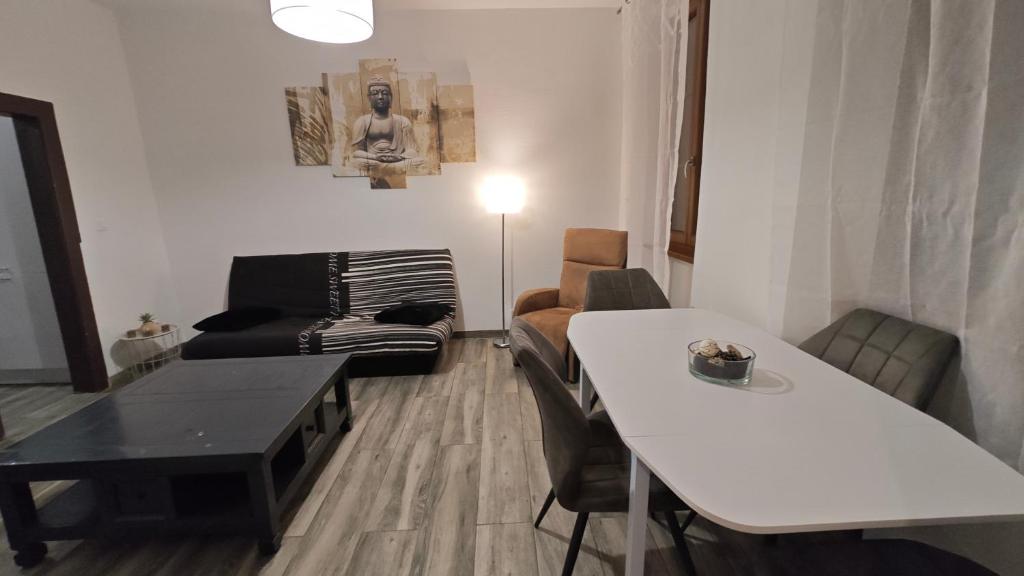 a living room with a white table and a couch at Appartement Sélestat centre in Sélestat