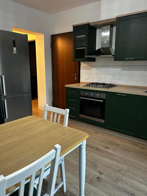 a kitchen with green cabinets and a wooden table with chairs at Via De'Amicis in Certaldo