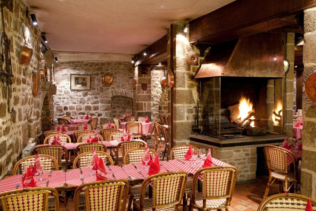 a restaurant with a table and chairs and a fireplace at Auberge Saint Pierre in Le Mont Saint Michel