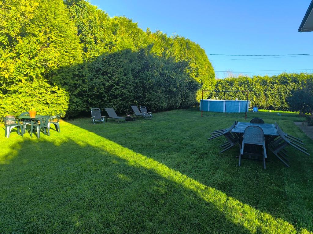 einen Hinterhof mit einem Tisch und Stühlen auf dem Gras in der Unterkunft Gran chalet con jardín, piscina y BBQ in Sada