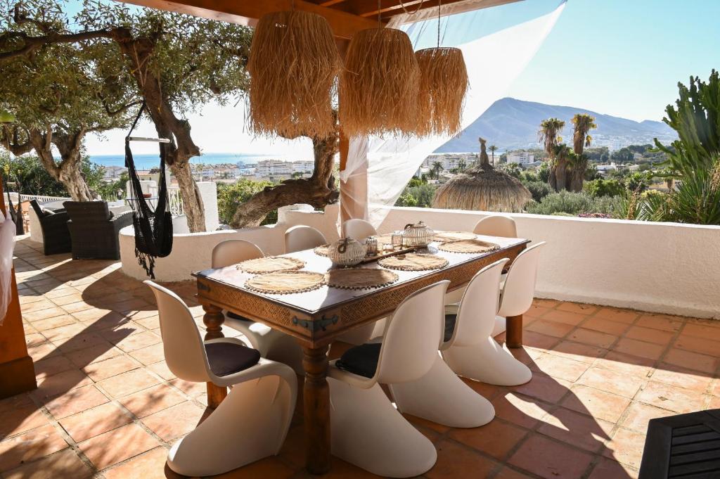 a dining room with a table and chairs on a patio at Villa Samar Altea Grupo Terra de Mar, alojamientos con encanto in Altea