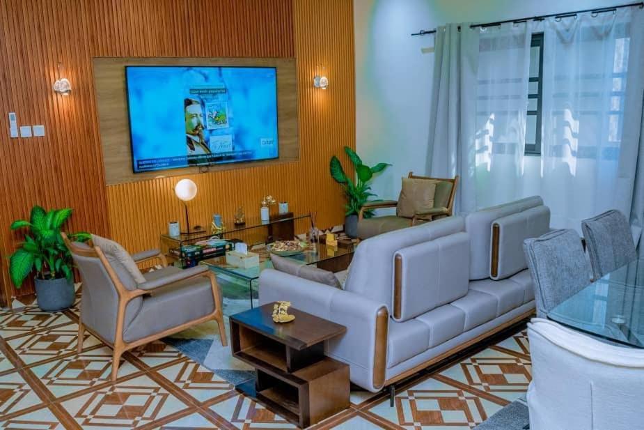 a living room with a couch and chairs and a tv at Furnished Downtown 2 Bedrooms in Brazzaville