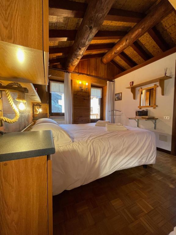 a bedroom with a large bed in a room with wooden ceilings at La Maison del Bon Grato in Champorcher