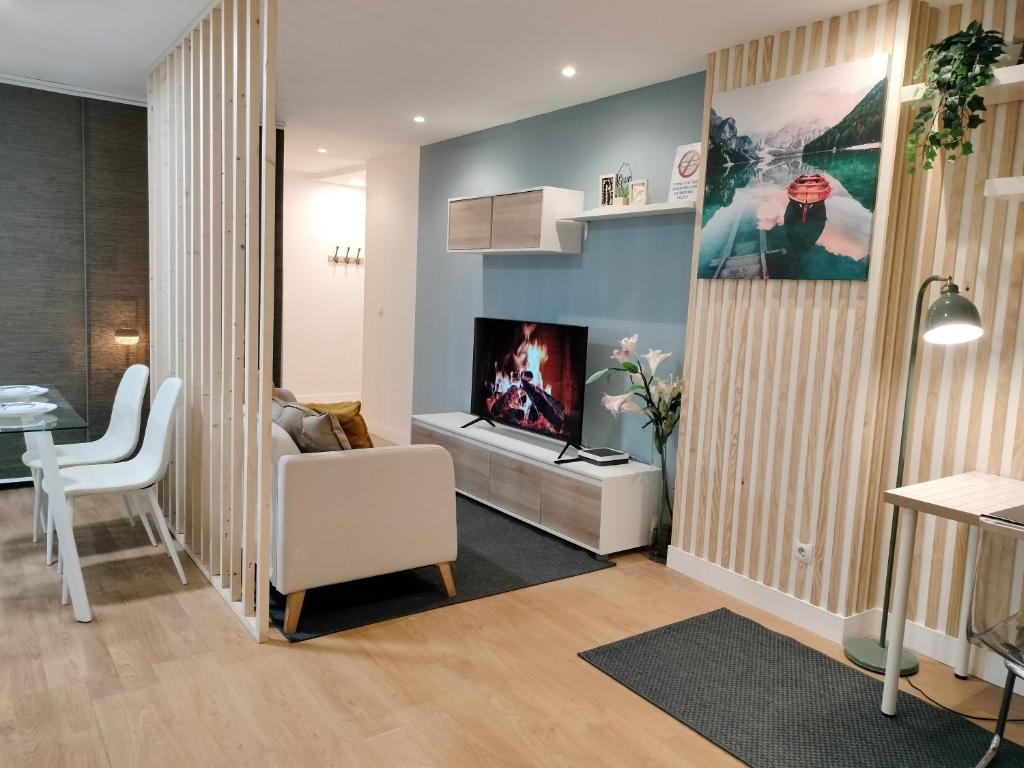 - un salon avec une cheminée et une chaise blanche dans l'établissement ESTUDIOS 55 - - CÉNTRICO - RH Santander, à Santander