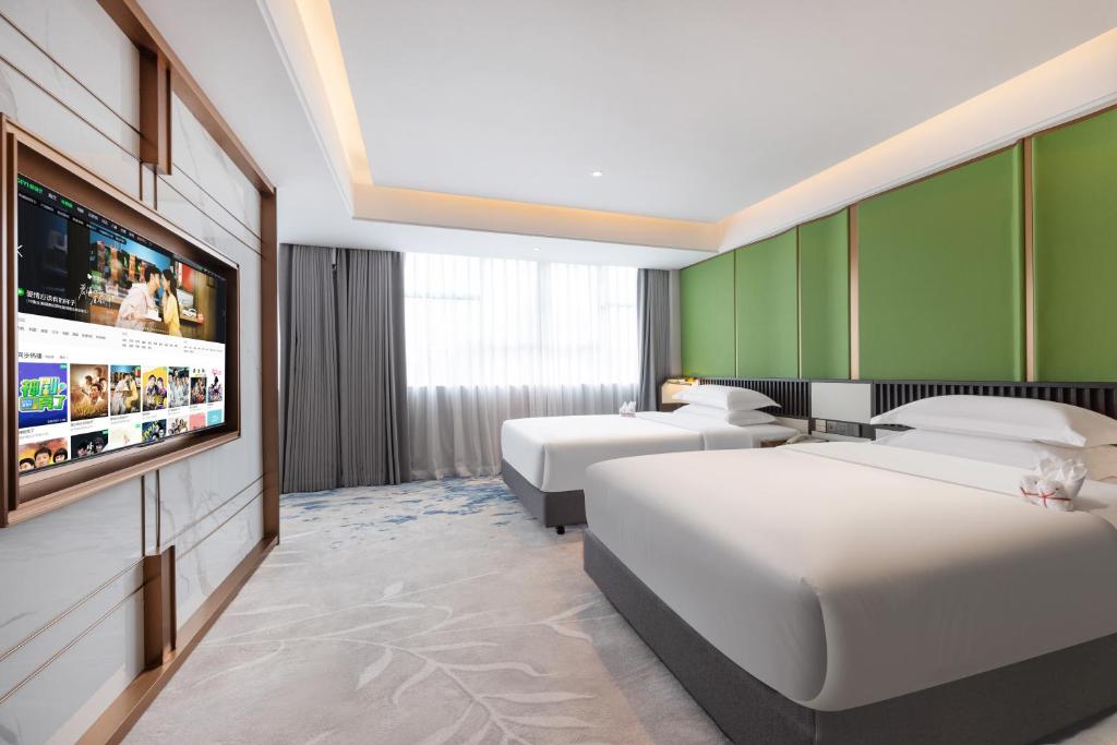 Postel nebo postele na pokoji v ubytování Sanyu Hotel
