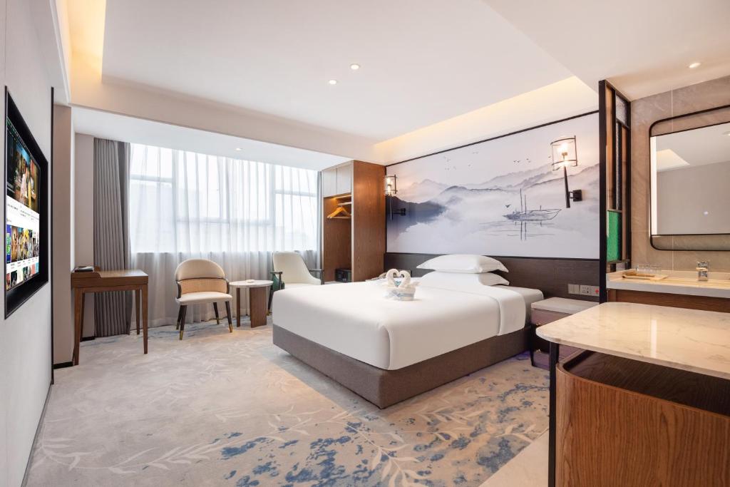 Postel nebo postele na pokoji v ubytování Sanyu Hotel