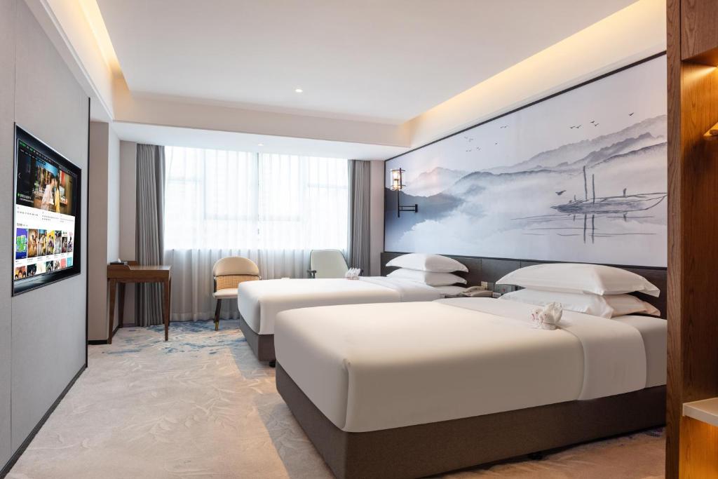 Postel nebo postele na pokoji v ubytování Sanyu Hotel