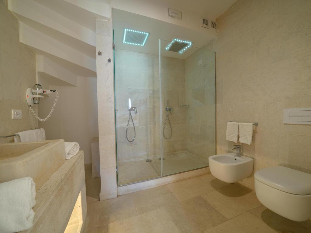 a bathroom with a shower and a toilet and a sink at HOTEL BARONE DI MARE in Torre dell'Orso