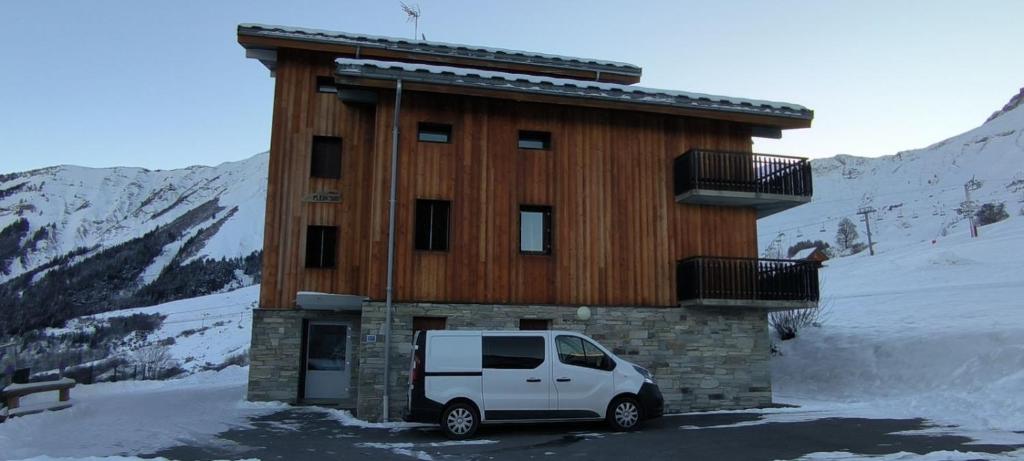 艾尔比蒙通Appartement au pied des pistes的一辆白色厢式货车停在一栋建筑物前。