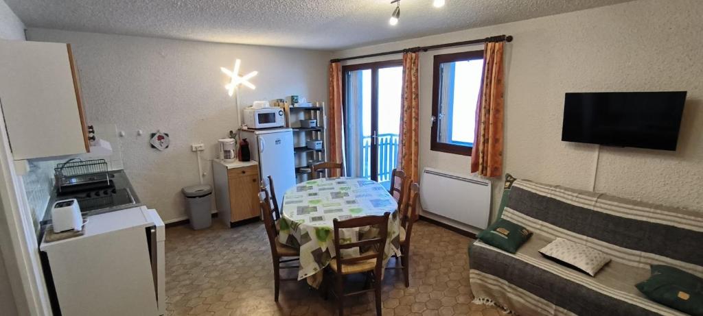 Il comprend un petit salon avec une table et une cuisine. dans l'établissement Appartement au pied des pistes, à Albiez-Montrond