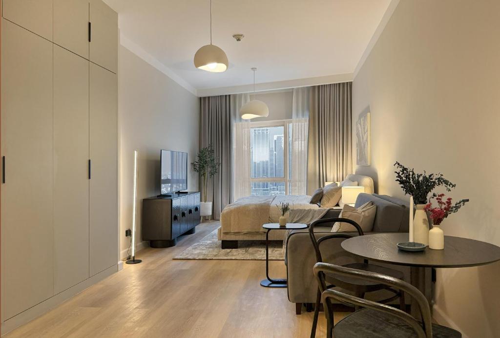 a living room with a bed and a table at Signature Studio JLT in Dubai