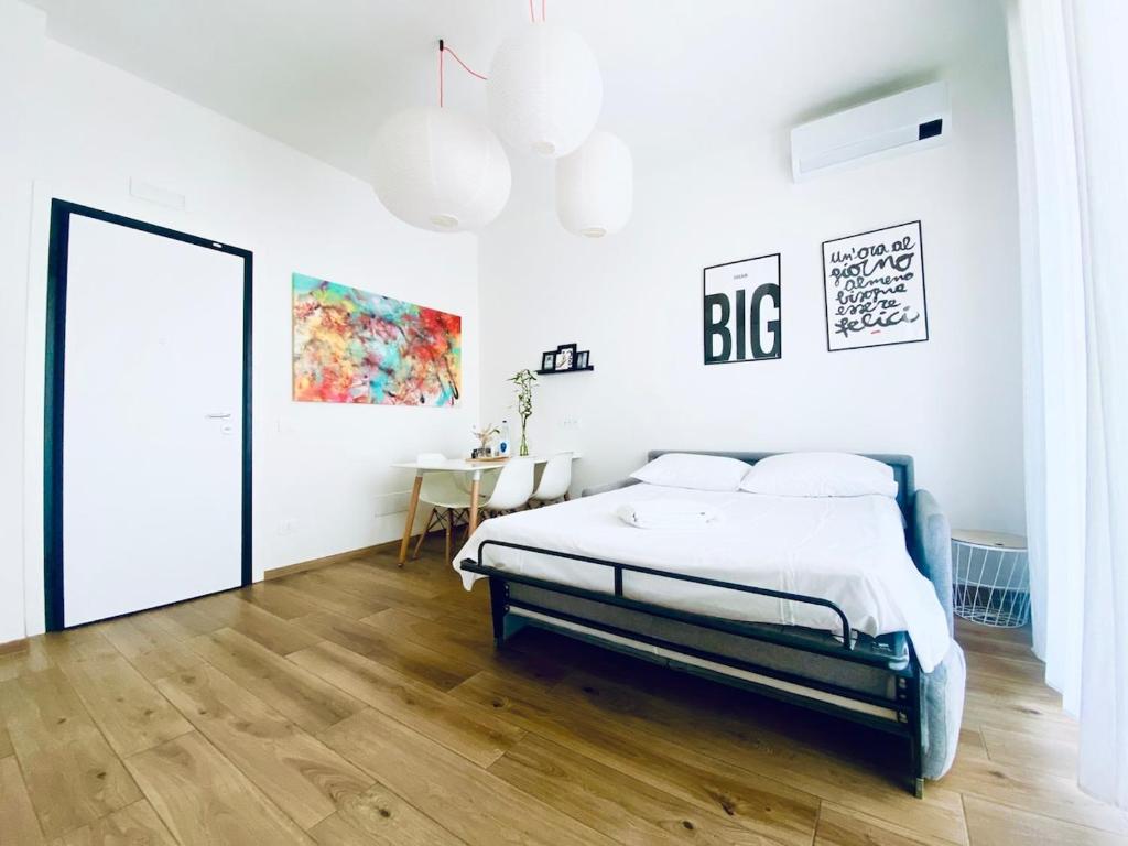 a white bedroom with a bed and a table at M4 WHITE Monolocale Moderno e Funzionale in Scandicci