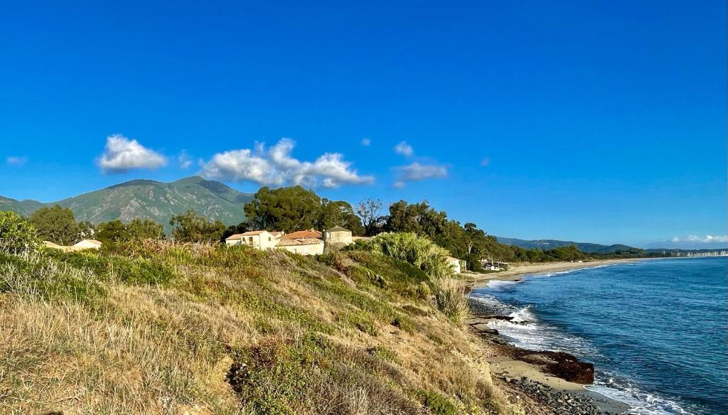 une maison sur une colline à côté d'une masse d'eau dans l'établissement Casabella 3 chambres, à Cervione