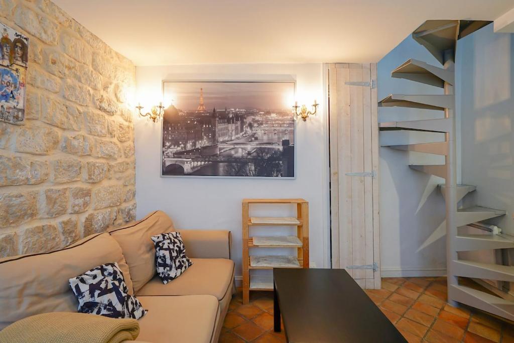 un salon avec un canapé et un mur de briques dans l'établissement Maison au coeur du Marais - II, à Paris