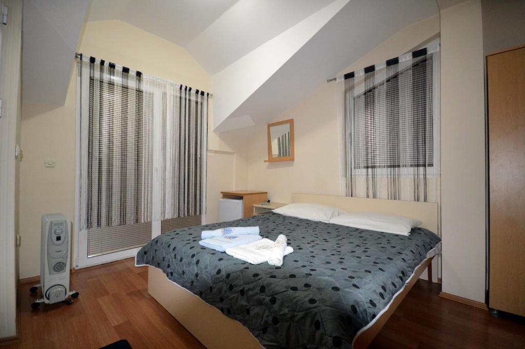una camera con un letto in una stanza con finestre di Mitko's Guest House a Ohrid