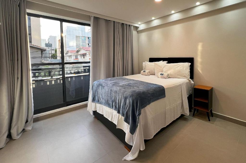 a bedroom with a bed and a large window at Intermares Quartz Studio 2 Pessoas 150m Praia in Ilha da Restinga