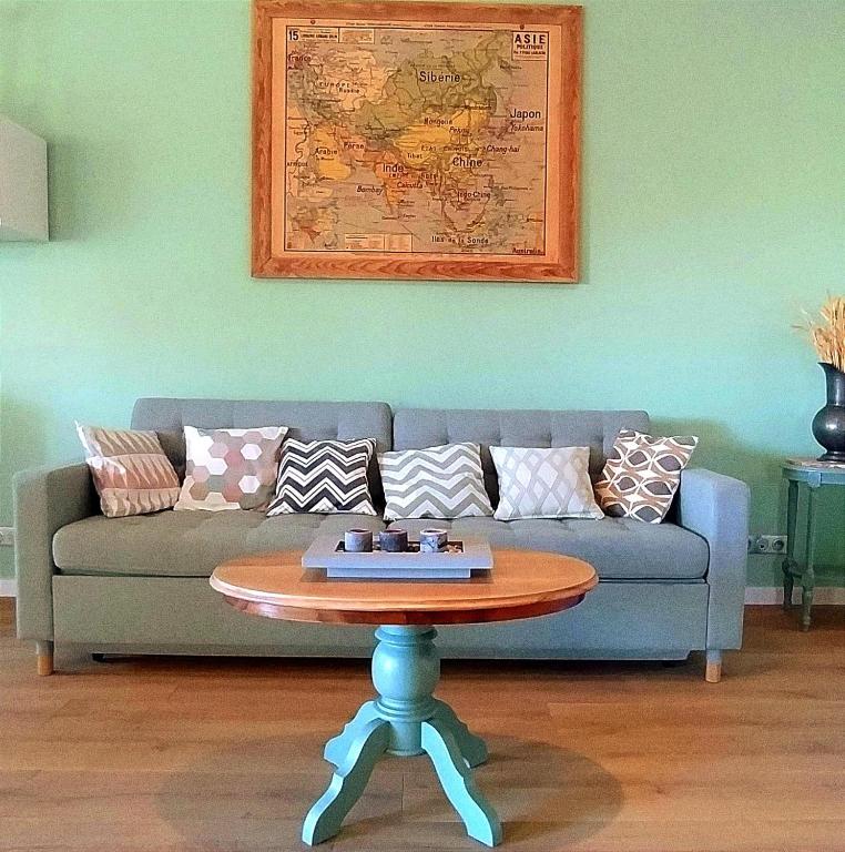 a living room with a couch and a table at Charmant Cottage in Châtenois