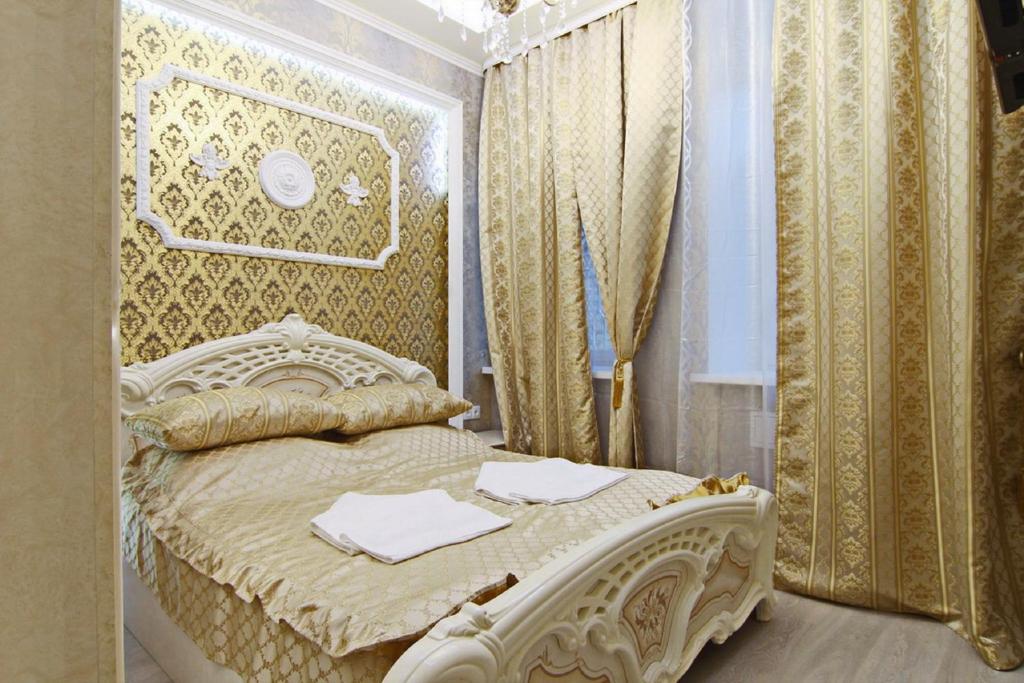 białe łóżko w pokoju z zasłonami w obiekcie Apollo w Petersburgu