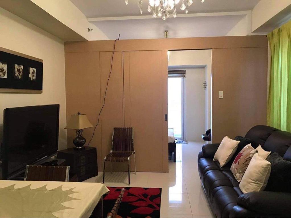 a living room with a couch and a television at Smdc wind residences tower 1 in Tagaytay