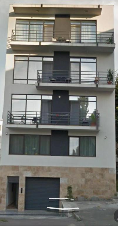 a tall white building with balconies on the side of it at City Park Residence in Constanţa