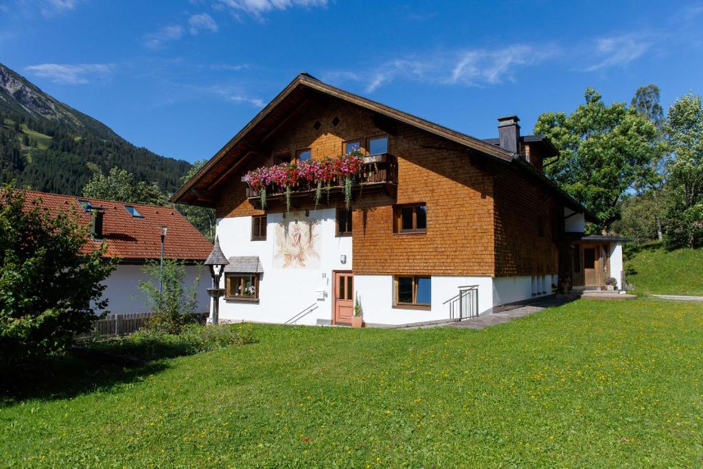 a house with a balcony and flowers on it at Haus Maringele in Nesselwängle