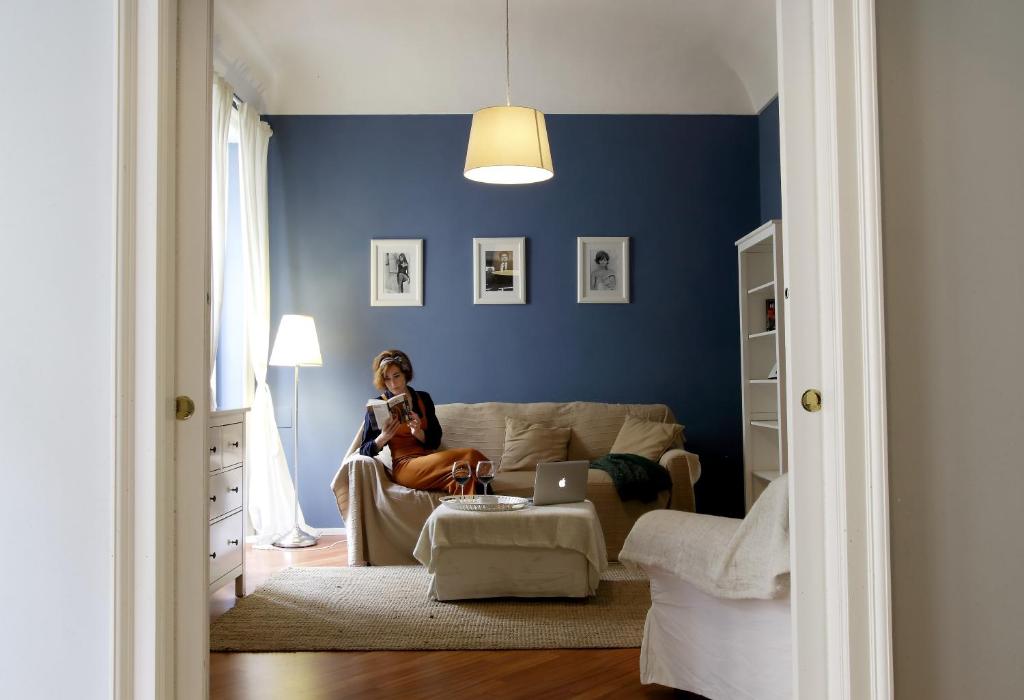 una mujer sentada en un sofá en una sala de estar en Ortigia Guest House Casa Flora, en Siracusa