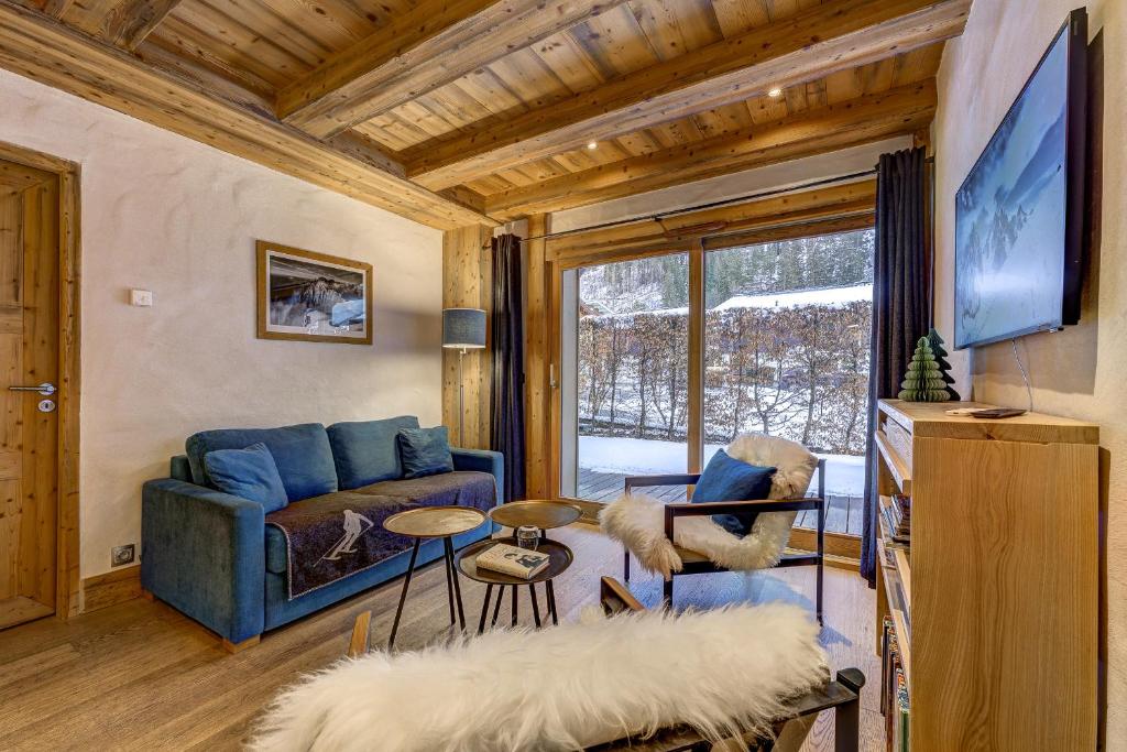 un salon avec un canapé bleu et une télévision dans l'établissement Blaitiere 2 Apartment, à Chamonix-Mont-Blanc