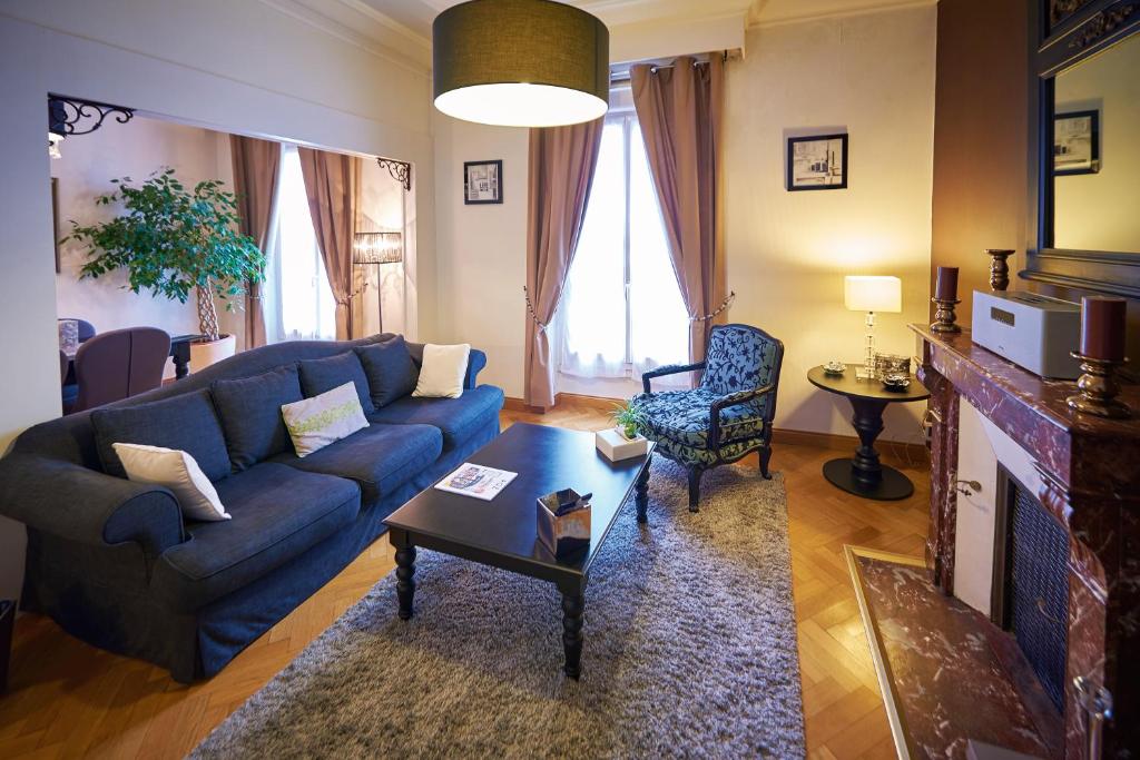 sala de estar con sofá azul y mesa en Appartements Plantagenet - Le 33, en Le Mans