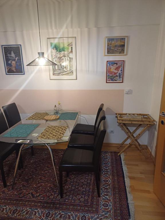 a dining room with a glass table and black chairs at Milutin in Pale