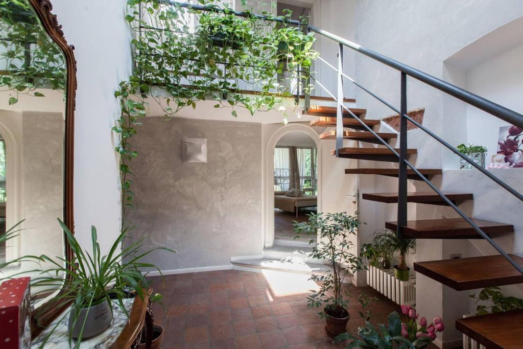 a hallway with a spiral staircase with plants at Gioia House in Milan