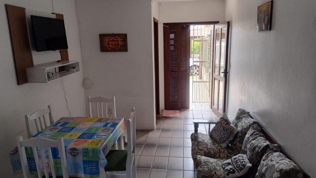 a living room with a couch and a table and a television at Apartamento Duplex na praia de Salinas RS in Cidreira