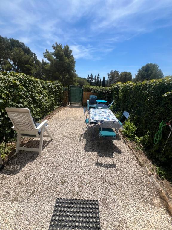 d'une terrasse avec une table et des chaises dans le jardin. dans l'établissement Studio proche mer avec jardinet, aux Lecques