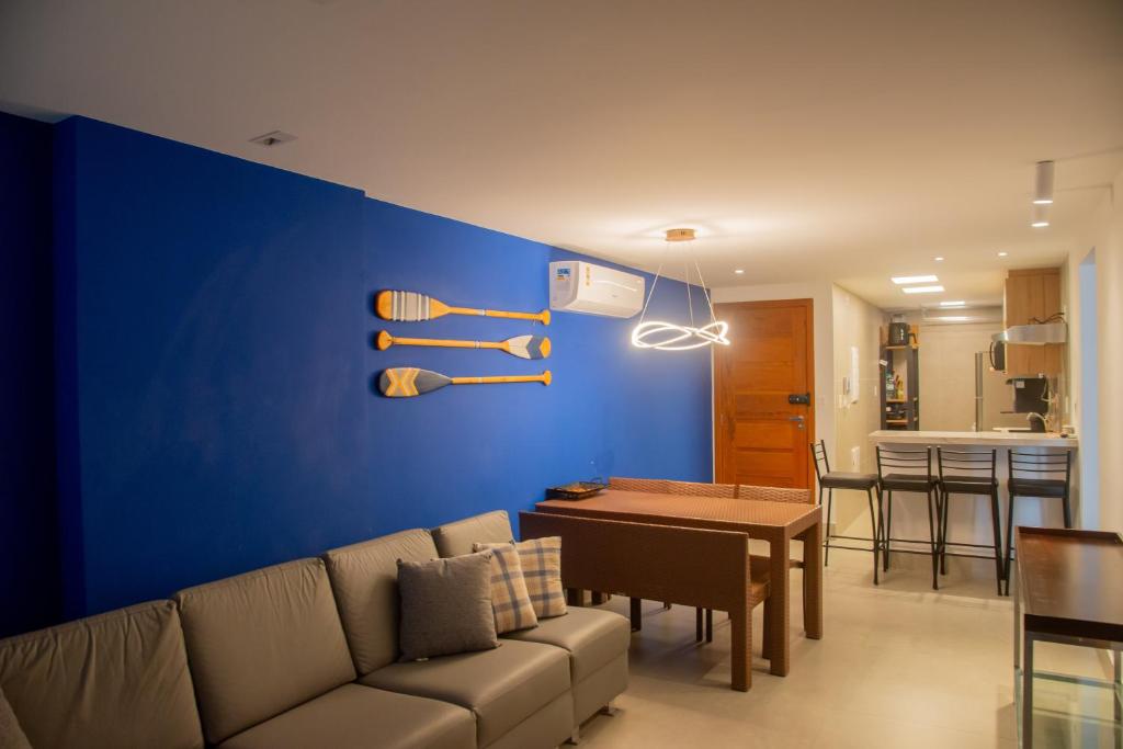 a living room with a couch and a blue wall at Guarapari Bacutia Peracanga an1 in Guarapari