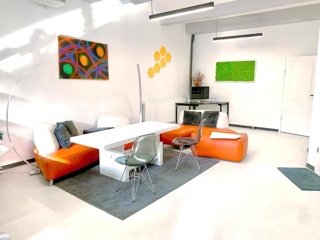 sala de estar con sillas de color naranja y mesa blanca en Modern Central Leiden Family Apt - Sleeps 6 and Baby, en Leiden