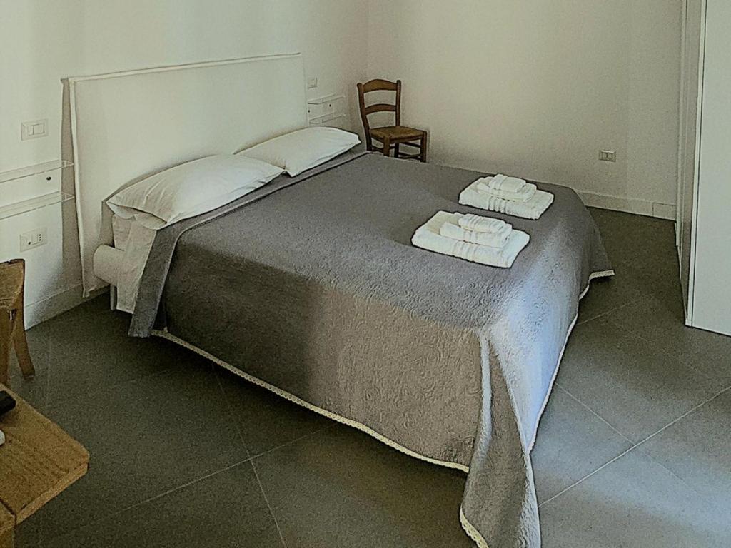 a bedroom with a large bed with two towels on it at Dimora Storica Apartments in Ruviano