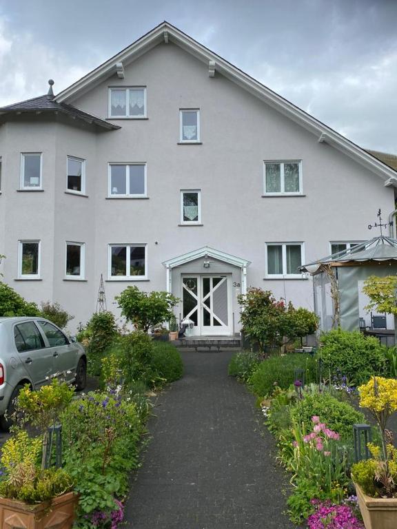 a white house with a car parked in front of it at Ferienwohnung Alexa an der Dhron in Neumagen-Dhron