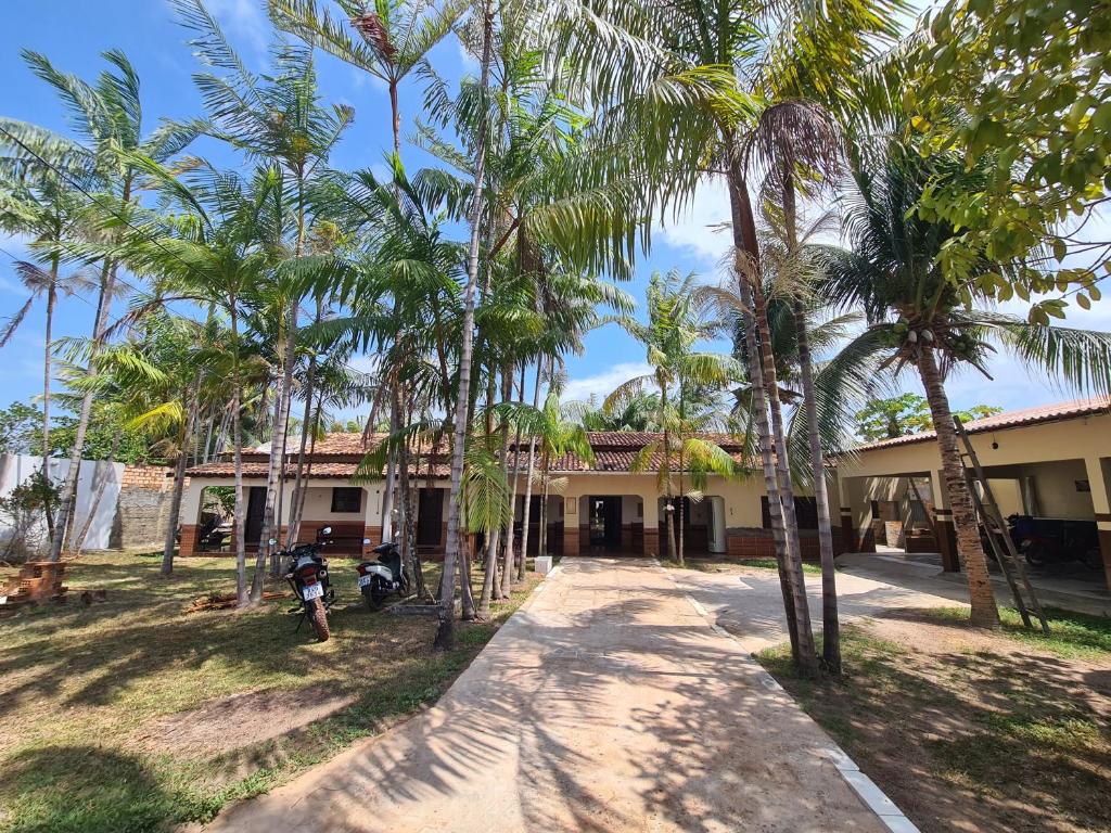 a building with palm trees in front of it at Hospedagem e queijaria Péua in Soure