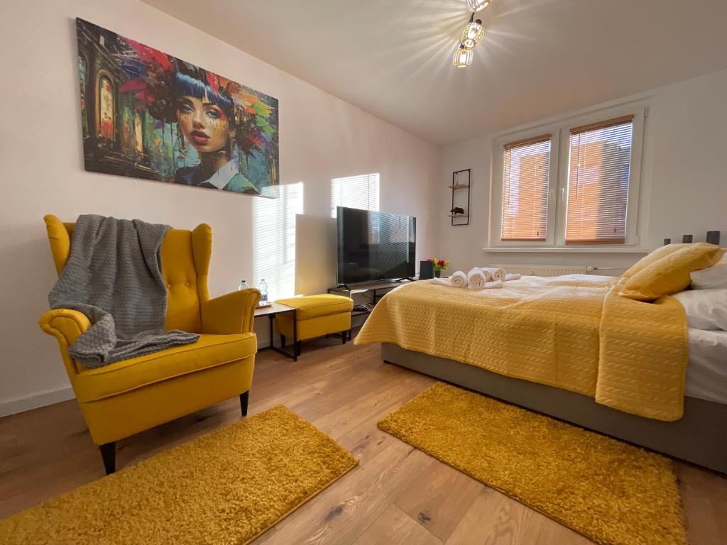 um quarto com uma cama, uma televisão e uma cadeira em Silesia Blue2 Apartment - Katowice em Katowice