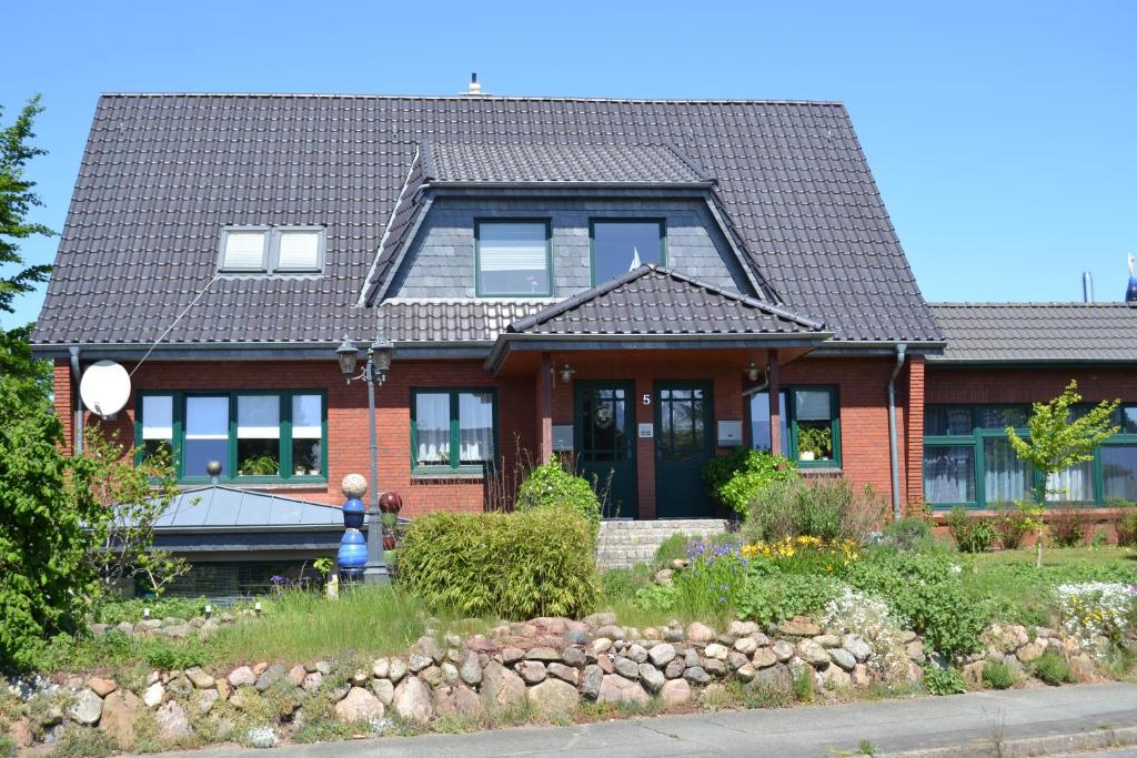 a red brick house with a black roof at LeaID in Idstedt