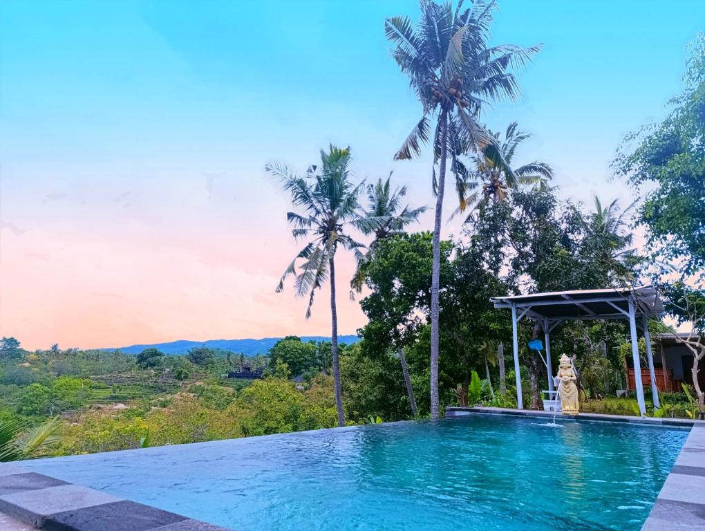 a swimming pool in a villa with palm trees at Green Sunrise Hill View in Nusa Penida